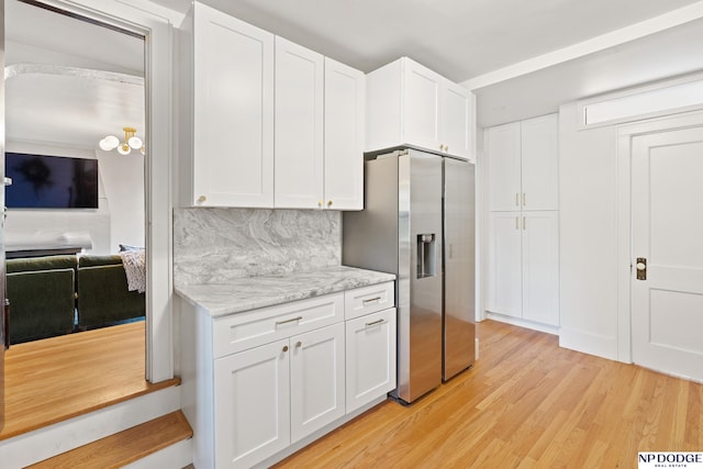 kitchen featuring stainless steel fridge, light wood-type flooring, and white cabinets
