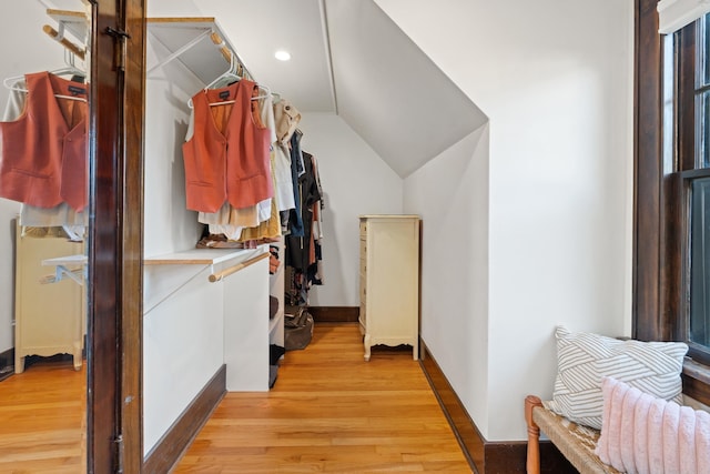 walk in closet with lofted ceiling and light wood-style flooring