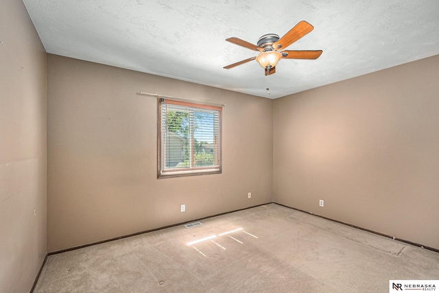 carpeted empty room with a ceiling fan and baseboards