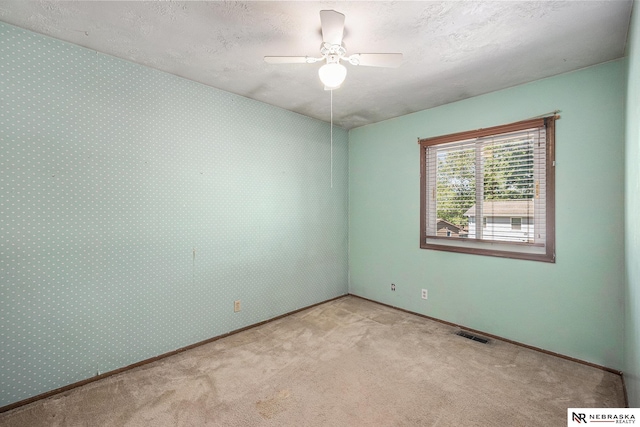 unfurnished room featuring carpet floors, ceiling fan, baseboards, and a textured ceiling