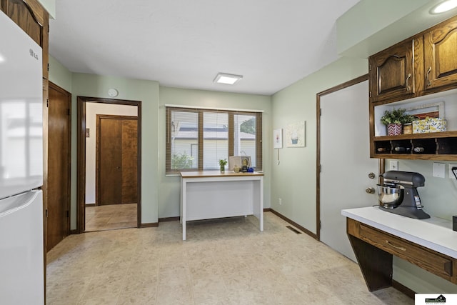 3041 Orwell St, Lincoln, NE 68516 - kitchen featuring freestanding refrigerator, light countertops, open shelves, a desk, and baseboards