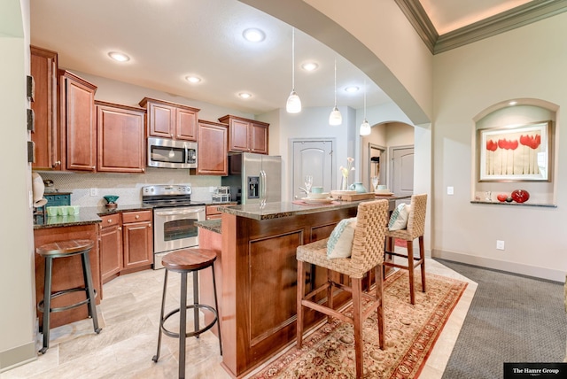 5758 N 157th St, Omaha, NE 68116 - kitchen featuring appliances with stainless steel finishes, arched walkways, a kitchen breakfast bar, crown molding, and a center island