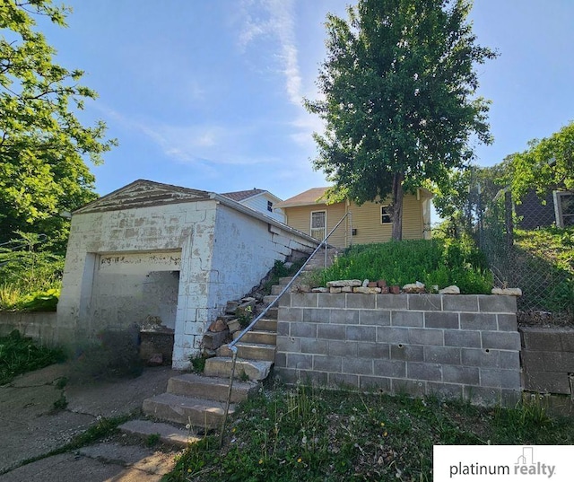 2436 S 23rd St, Omaha, NE 68108 - view of front of house with stairway, an attached garage, and stone siding