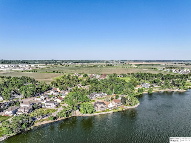 aerial view of property and surrounding area featuring a nearby body of water and nearby suburban area