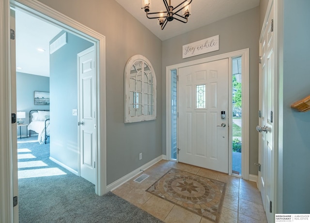 entrance foyer with a chandelier, baseboards, and light tile patterned floors