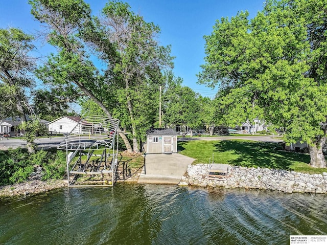 dock with a yard, a water view, and view of scattered trees