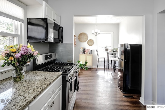 kitchen with black appliances, dark wood-style floors, white cabinets, decorative backsplash, and light stone counters