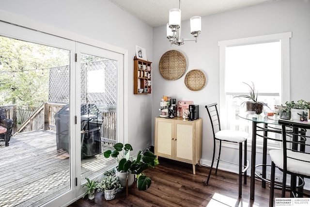 dining space featuring wood finished floors, a chandelier, and baseboards