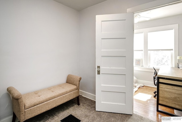 living area with ceiling fan, baseboards, and wood finished floors
