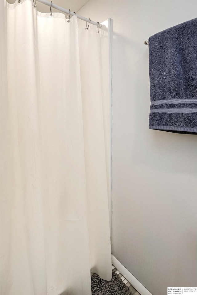 bathroom with baseboards and a shower with shower curtain