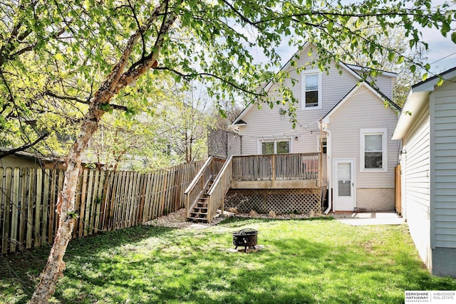 back of property with an outdoor fire pit, a wooden deck, and stairway