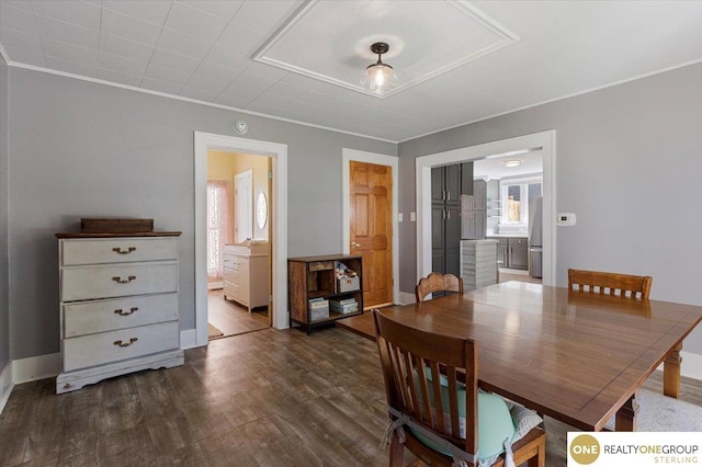 dining space featuring dark wood-style floors, crown molding, and baseboards