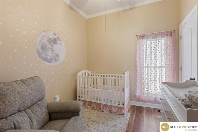 bedroom with ornamental molding and wood finished floors