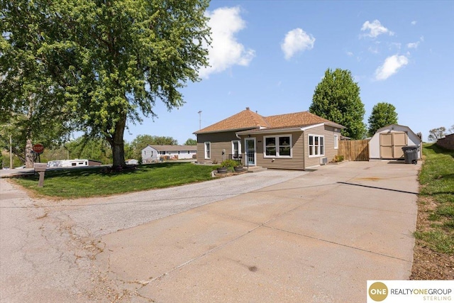 view of front of home featuring a shed, driveway, and an outbuilding