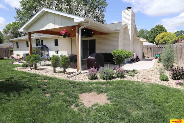 2804 Hogan Ln, Fremont, NE 68025 - rear view of property with a patio area, a chimney, and board and batten siding