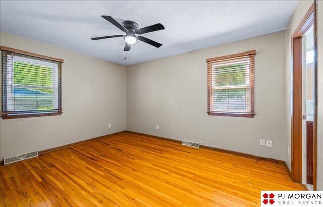 13577 Shirley St, Omaha, NE 68144 - unfurnished room featuring healthy amount of natural light, light wood-style floors, ceiling fan, and baseboards