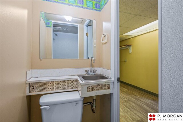 13577 Shirley St, Omaha, NE 68144 - half bathroom with wood finished floors, toilet, a sink, and baseboards