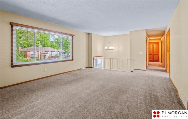 13577 Shirley St, Omaha, NE 68144 - spare room featuring a chandelier, carpet flooring, baseboards, and a textured ceiling