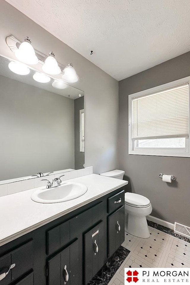 2307 N 142nd St, Omaha, NE 68164 - bathroom with vanity, toilet, a textured ceiling, and baseboards