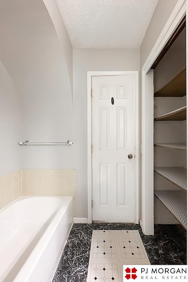 2307 N 142nd St, Omaha, NE 68164 - full bath featuring marble look tiles, a garden tub, and a textured ceiling