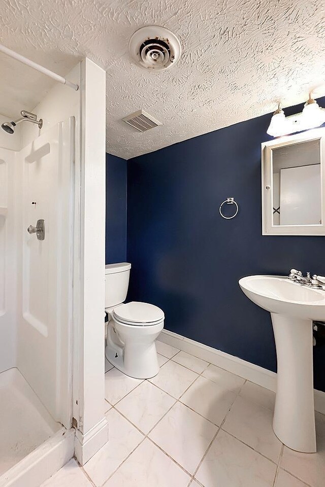 2307 N 142nd St, Omaha, NE 68164 - full bathroom featuring a stall shower, toilet, a textured ceiling, and baseboards