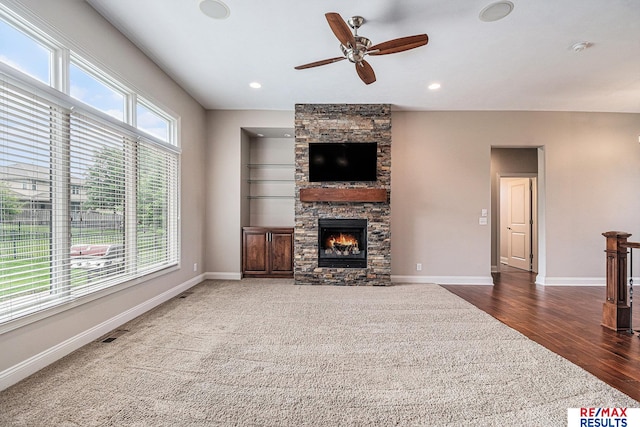 948 S 198th St, Omaha, NE 68022 - unfurnished living room with ceiling fan, wood finished floors, a stone fireplace, baseboards, and recessed lighting