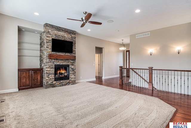 948 S 198th St, Omaha, NE 68022 - carpeted living room featuring ceiling fan, wood finished floors, baseboards, a stone fireplace, and recessed lighting