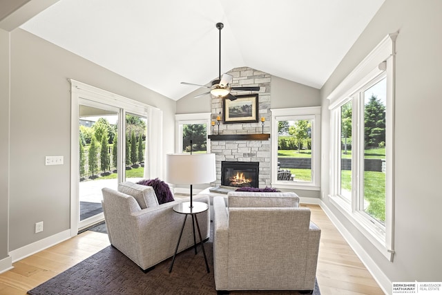 11412 S 122nd St, Papillion, NE 68046 - living room featuring a fireplace, a ceiling fan, light wood-type flooring, vaulted ceiling, and baseboards