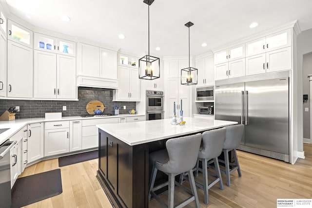 11412 S 122nd St, Papillion, NE 68046 - kitchen with built in appliances, white cabinetry, a kitchen island, light wood-type flooring, and recessed lighting