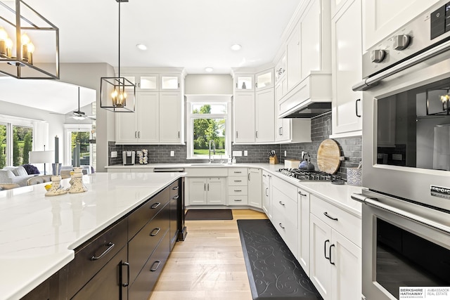 11412 S 122nd St, Papillion, NE 68046 - kitchen featuring stainless steel double oven, white cabinetry, a sink, healthy amount of natural light, and recessed lighting