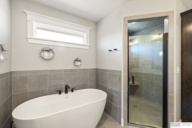 11412 S 122nd St, Papillion, NE 68046 - bathroom with a freestanding bath, a shower stall, tile walls, and tile patterned flooring