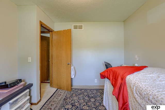carpeted bedroom with baseboards and a textured ceiling