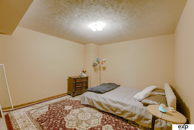 carpeted bedroom with a textured ceiling and baseboards
