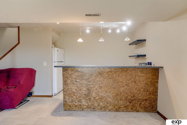 kitchen with freestanding refrigerator, light colored carpet, and baseboards
