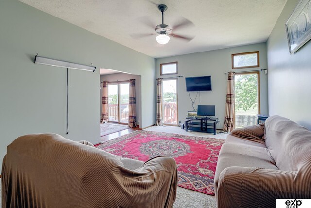 carpeted living area featuring ceiling fan