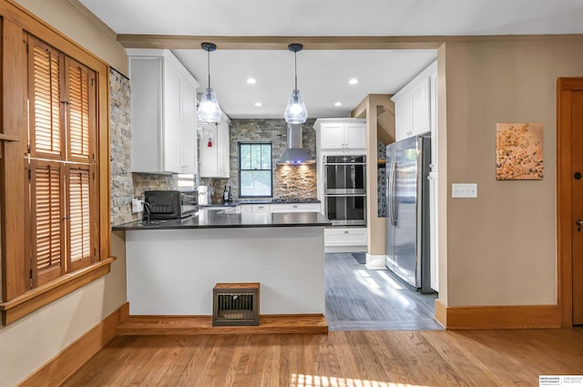 1530 S 52nd St, Omaha, NE 68106 - kitchen featuring appliances with stainless steel finishes, wall chimney exhaust hood, a peninsula, backsplash, and dark countertops