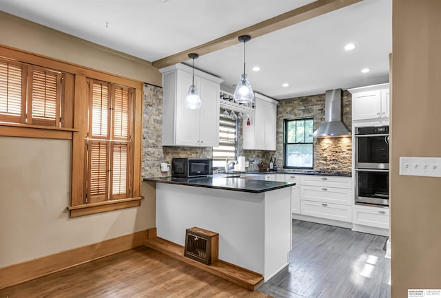 1530 S 52nd St, Omaha, NE 68106 - kitchen featuring wall chimney range hood, black microwave, wood finished floors, decorative backsplash, and recessed lighting