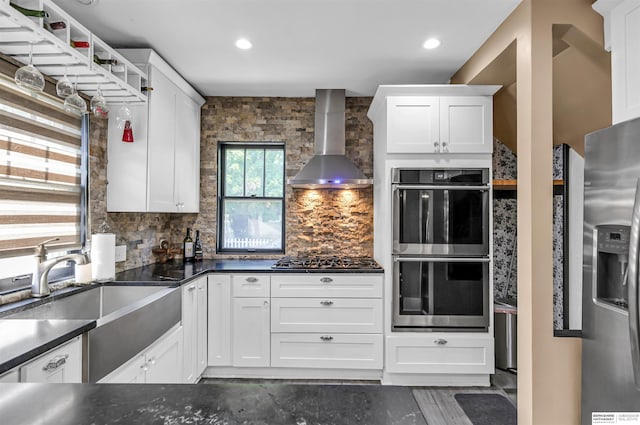 1530 S 52nd St, Omaha, NE 68106 - kitchen featuring wall chimney range hood, appliances with stainless steel finishes, dark countertops, white cabinets, and recessed lighting