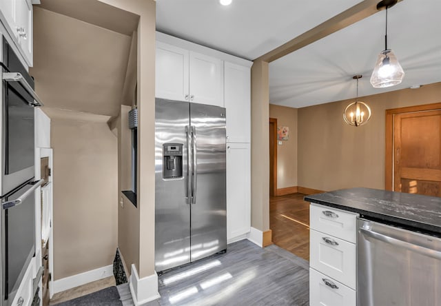 1530 S 52nd St, Omaha, NE 68106 - kitchen featuring stainless steel appliances, light wood-type flooring, white cabinetry, pendant lighting, and a chandelier