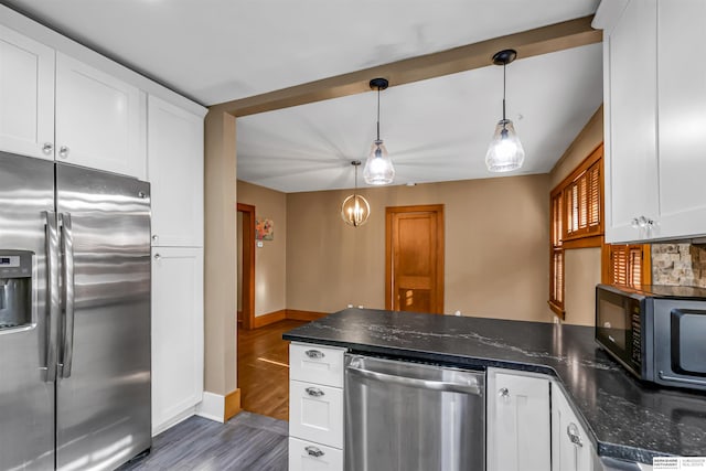 1530 S 52nd St, Omaha, NE 68106 - kitchen featuring appliances with stainless steel finishes, a peninsula, white cabinets, wood finished floors, and dark stone counters
