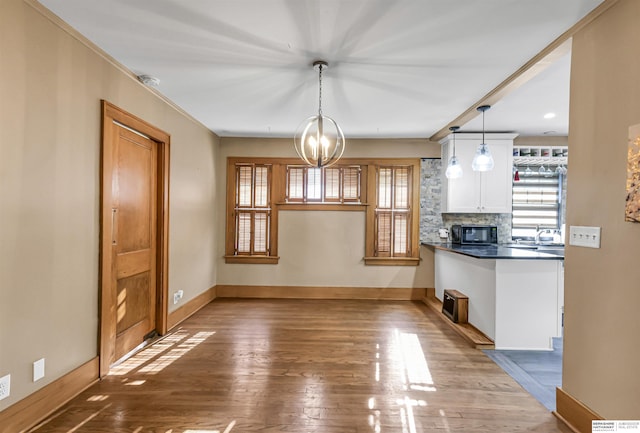 1530 S 52nd St, Omaha, NE 68106 - unfurnished dining area with wood finished floors, a chandelier, and crown molding