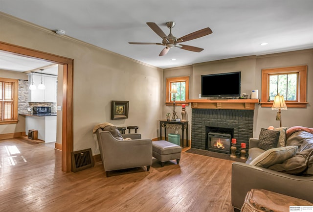 1530 S 52nd St, Omaha, NE 68106 - living area featuring a brick fireplace, healthy amount of natural light, crown molding, hardwood / wood-style flooring, and recessed lighting