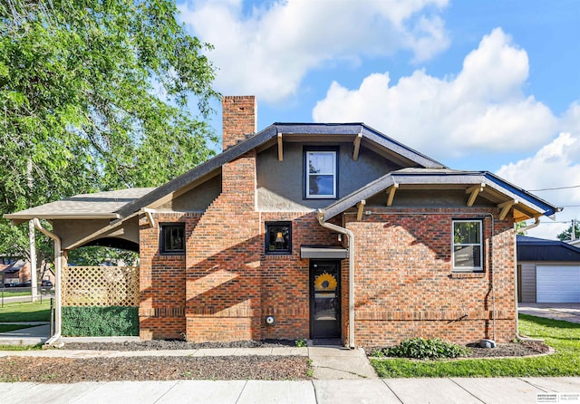 1530 S 52nd St, Omaha, NE 68106 - view of front of property featuring a chimney, brick siding, stucco siding, and an outdoor structure