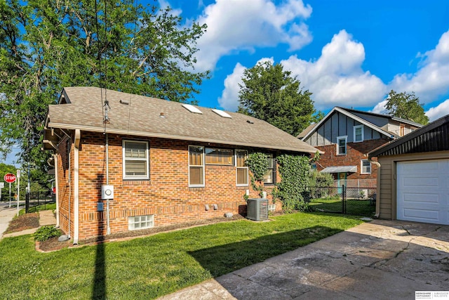 1530 S 52nd St, Omaha, NE 68106 - rear view of house featuring a shingled roof, concrete driveway, brick siding, a garage, and an outbuilding