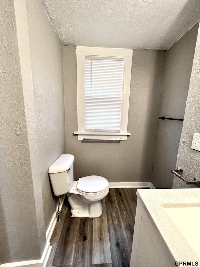 3941 X St, Omaha, NE 68107 - bathroom featuring wood finished floors, baseboards, toilet, a textured ceiling, and vanity