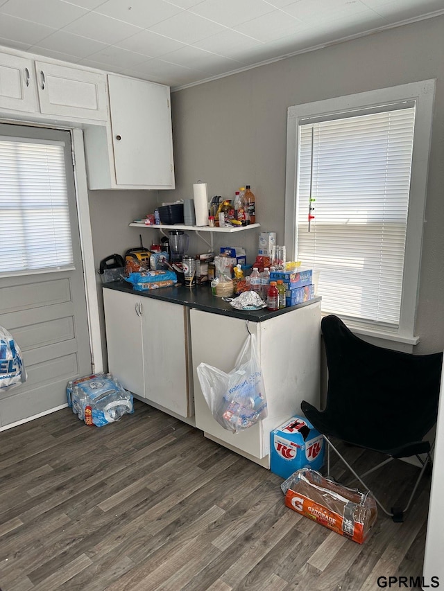 3941 X St, Omaha, NE 68107 - kitchen featuring healthy amount of natural light, white cabinetry, wood finished floors, dark countertops, and ornamental molding