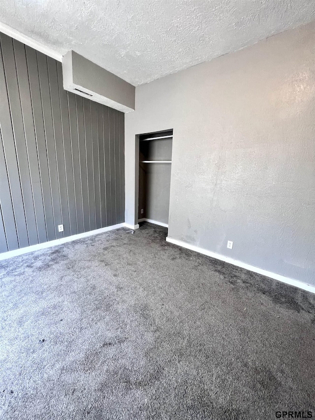 3941 X St, Omaha, NE 68107 - unfurnished bedroom featuring baseboards, a textured ceiling, carpet floors, and wooden walls