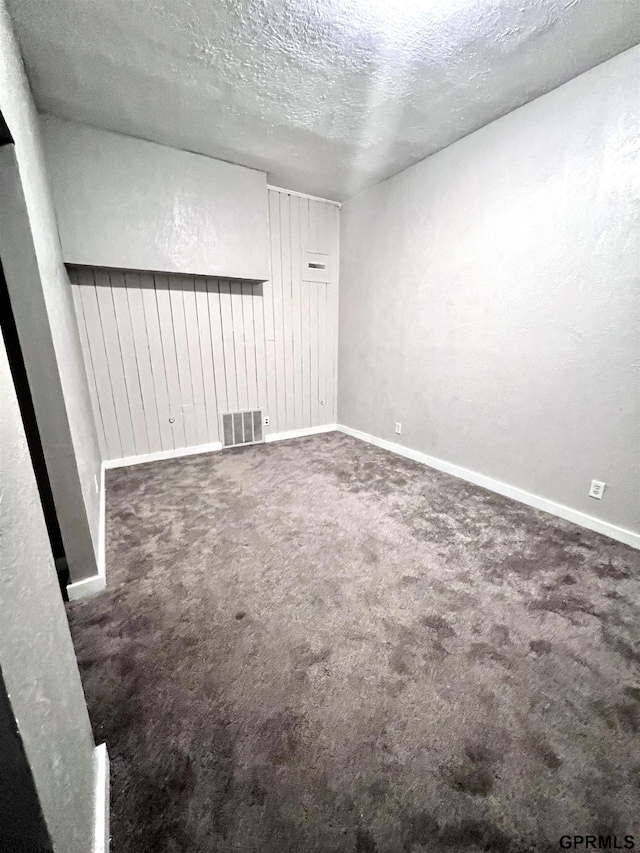 3941 X St, Omaha, NE 68107 - empty room featuring a textured ceiling, carpet flooring, and baseboards