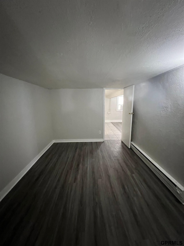 3941 X St, Omaha, NE 68107 - bonus room with baseboard heating, dark wood finished floors, a textured ceiling, and baseboards
