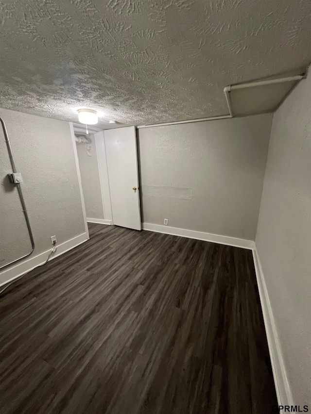 3941 X St, Omaha, NE 68107 - finished below grade area featuring dark wood-type flooring, a textured ceiling, and baseboards